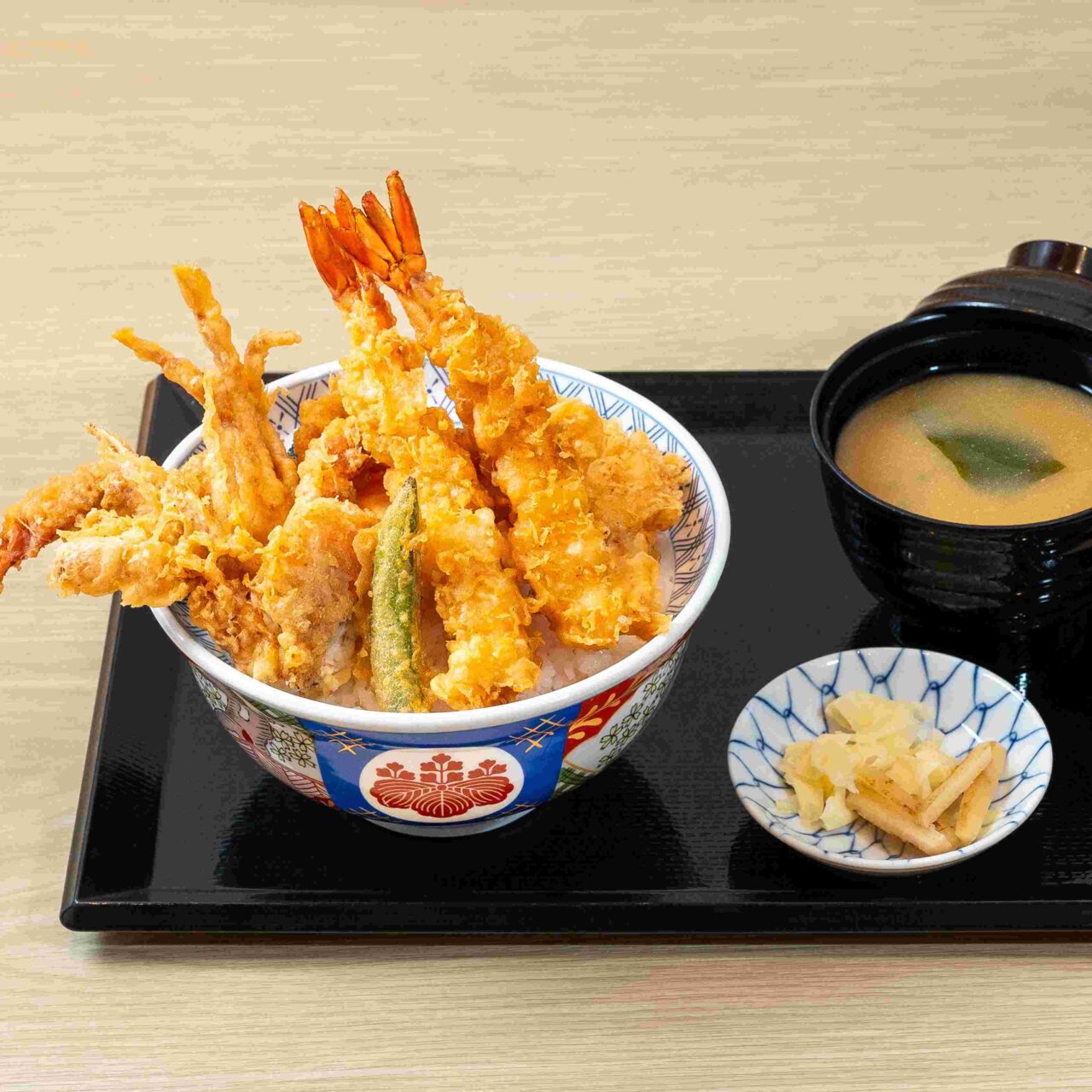 A lavishly topped bowl of authentic Japanese Edomae Tendon at Kaneko Hannosuke, featuring a variety of crispy tempura and secret savory sauce.