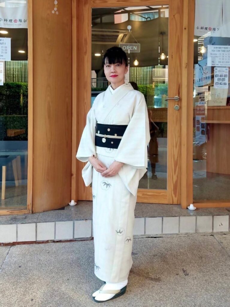 和服を着て店先に立つ、小料理結びのママの佐藤さん 手料理と手作りケーキが評判