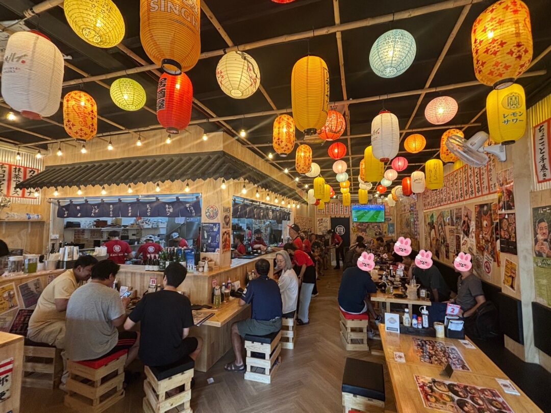 恵美須商店の活気ある店内。カウンター席やテーブル席で食事を楽しむ人々の様子。