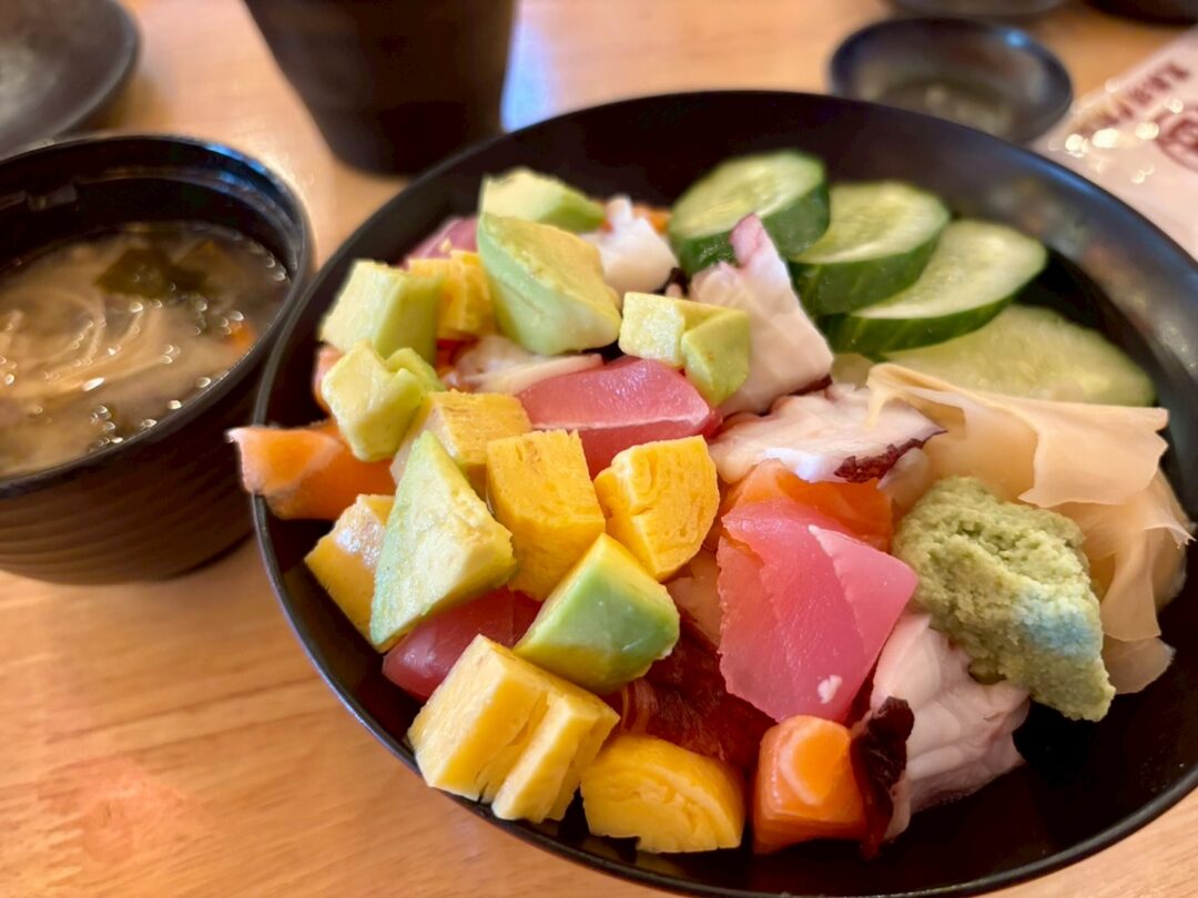 マグロ、サーモン、タコ、アボカド、きゅうり、卵焼きが乗った海鮮丼と、横に置かれた味噌汁。