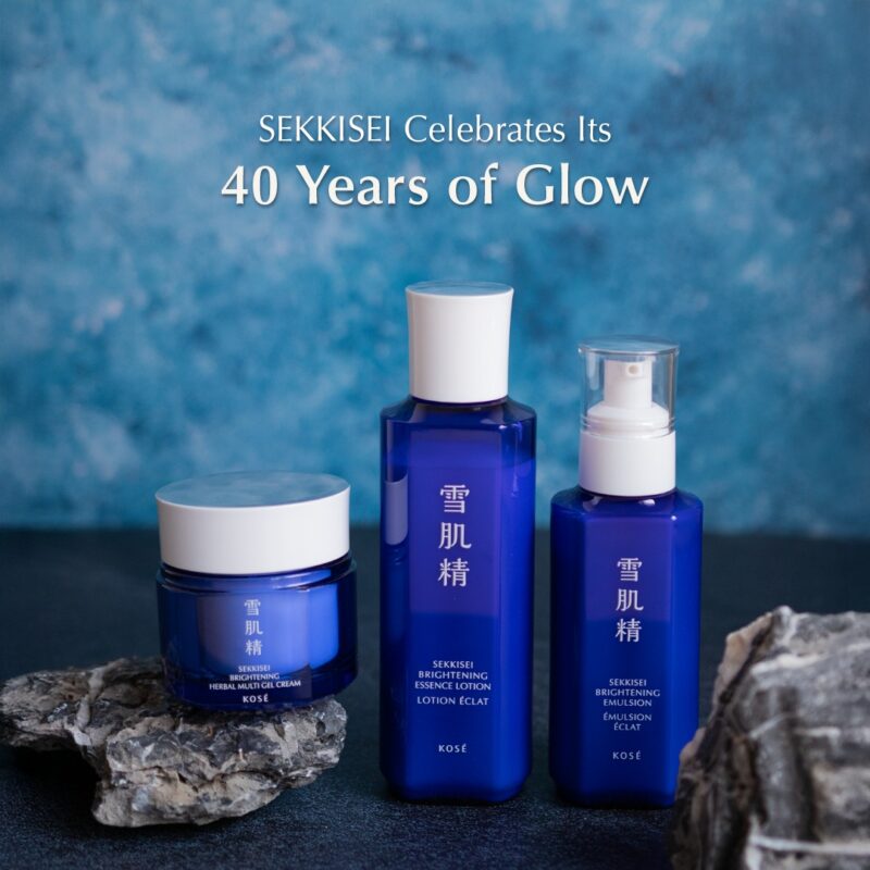 青いパッケージの雪肌精スキンケア商品（クリーム、ローション、エマルジョン）が岩の上に並べられている。背景にはブルーのグラデーション。