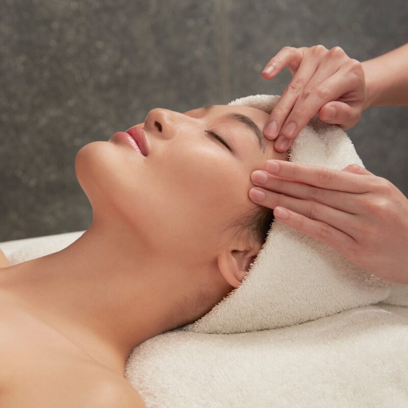 PAÑPURIスパでのフェイシャルマッサージ施術を受ける女性。リラックスして目を閉じている様子。