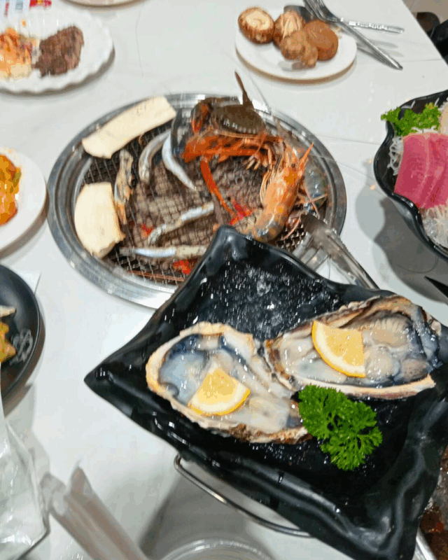 テーブルに埋め込まれた炭火で焼いていくスタイル 生牡蠣もあります