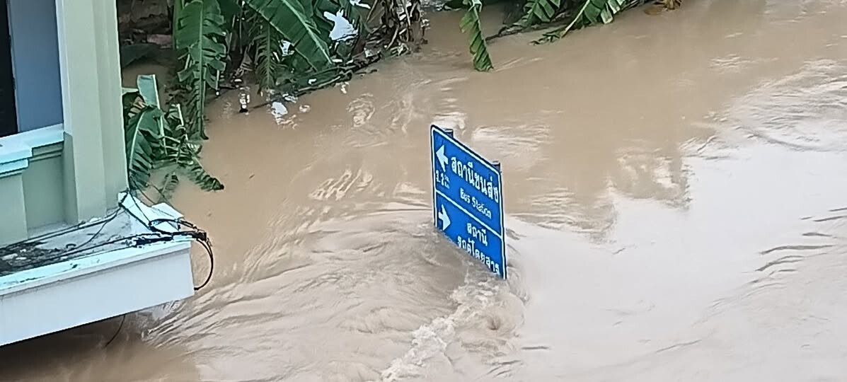 少しだけ下がった水位を看板で確認する様子